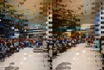 People in the school's auditorium watch the speech of the representative of the Stavros Niarchos Foundation (SNF), Lina Yiotaki